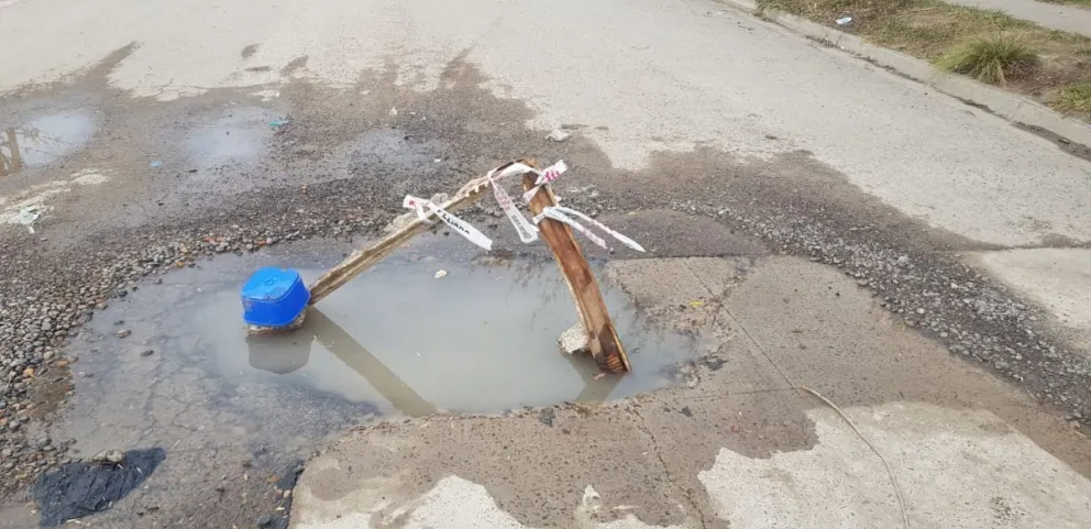 Un vecino señalizó un pozo con dos palos y un tarro de helado